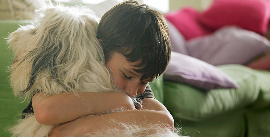 kid hugging dog