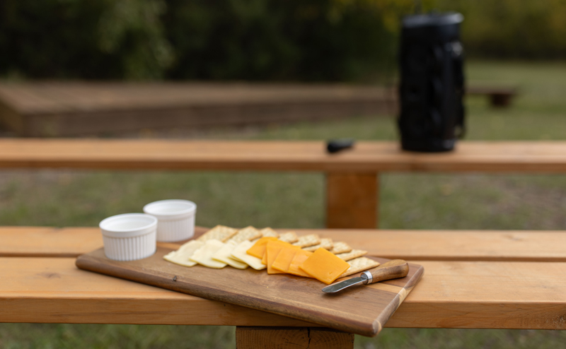 A charcuterie board on a picnic table.