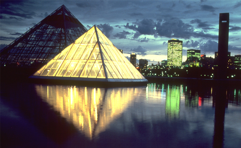 view of pyramids at night with downtown skyline in background