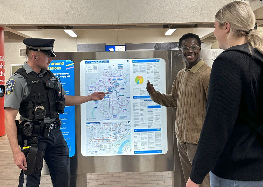 Transit Peace Officer helping LRT rider locate their destination on a transit map